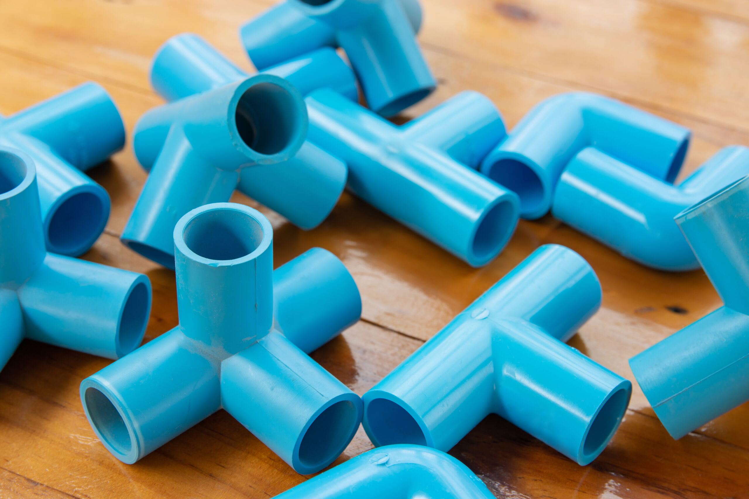 Blue pvc pipe fitting. Various type on wooden tables.